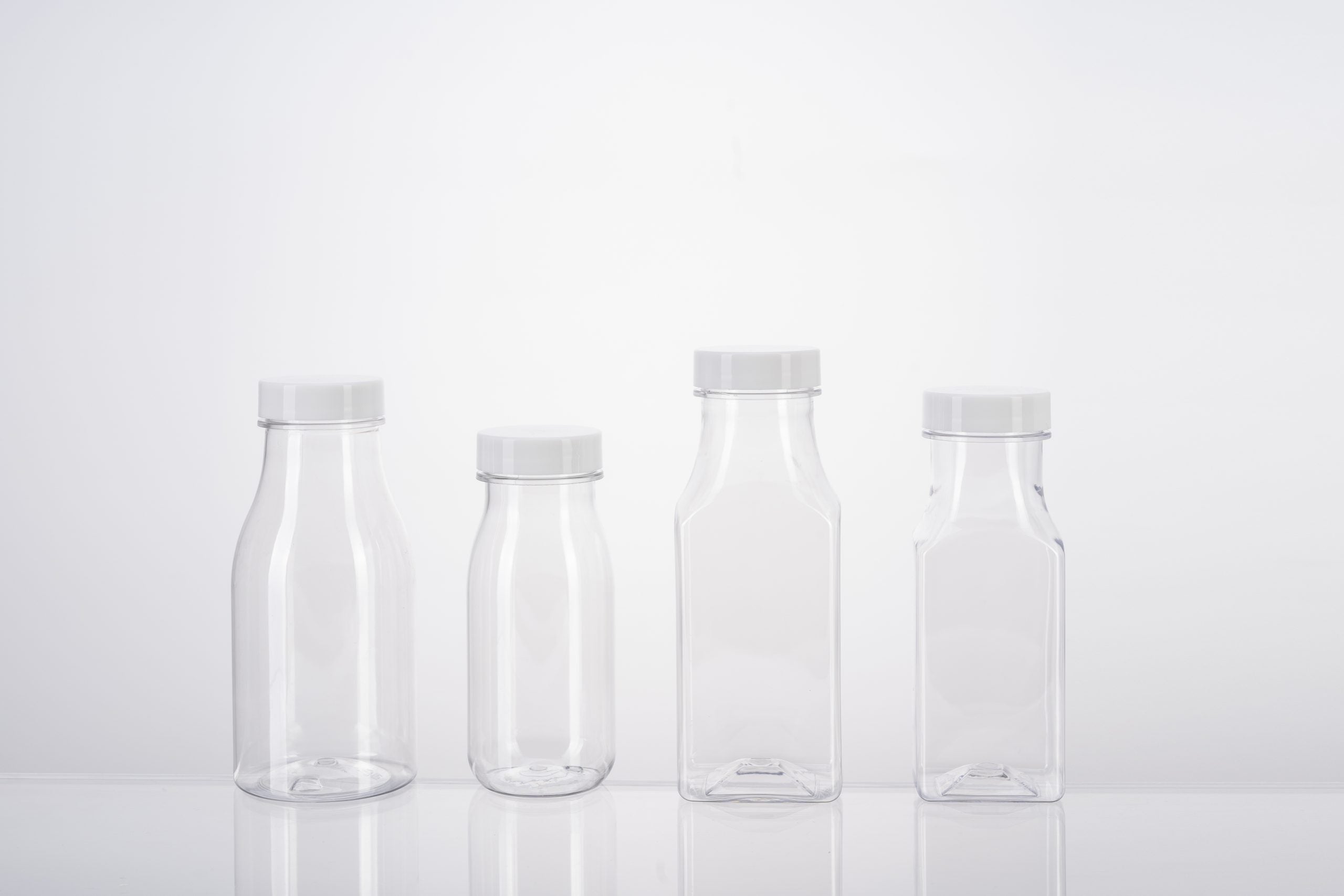 Clear PET square bottles stacked on pallets in a packaging production facility