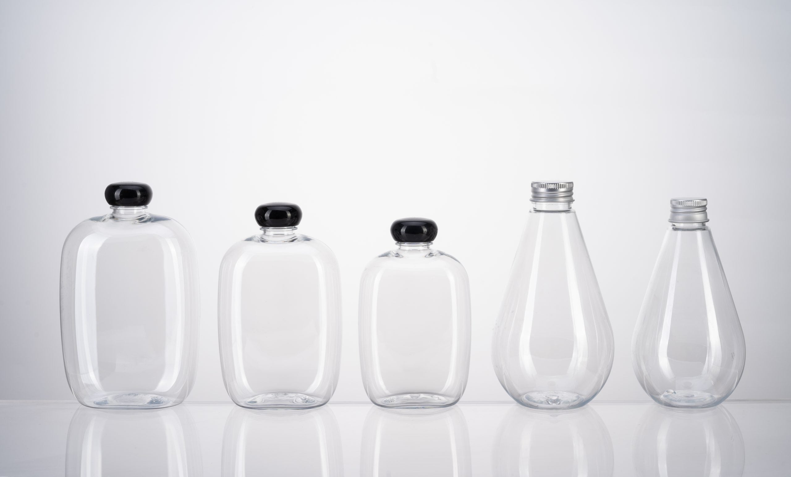 Clear PET square bottles stacked on pallets in a packaging production facility