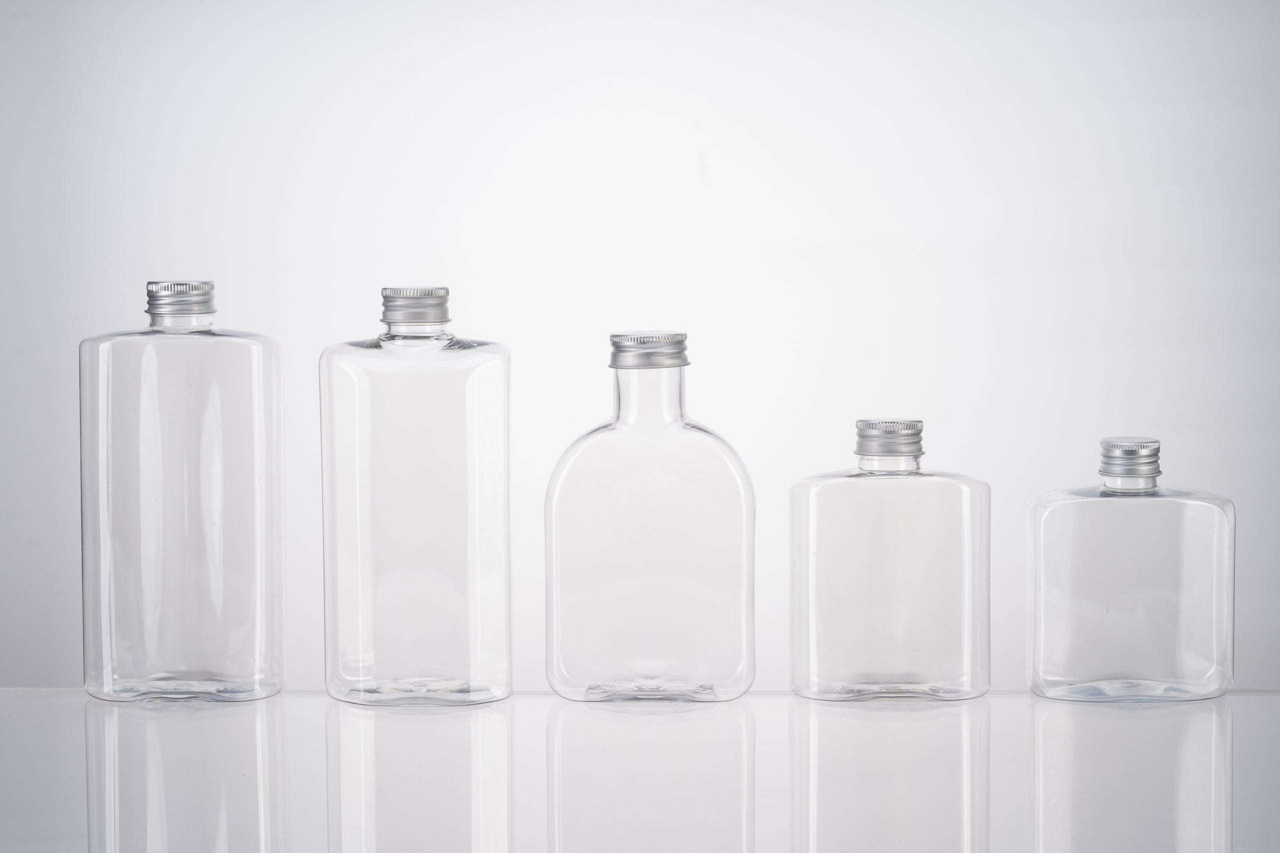 Clear PET square bottles stacked on pallets in a packaging production facility