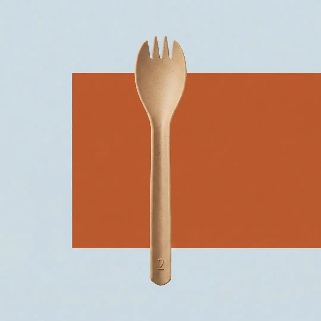 CompostEase | Spork centered on a clean background with geometric orange shape, emphasizing balanced proportions and plant-fiber material.