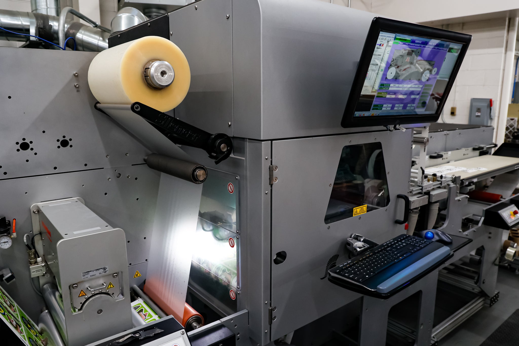 A high-tech die-cutting machine processing label materials with precision, featuring a digital interface for real-time monitoring.